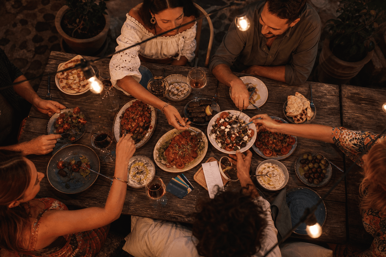Group of friends sharing a dinner table outdoors